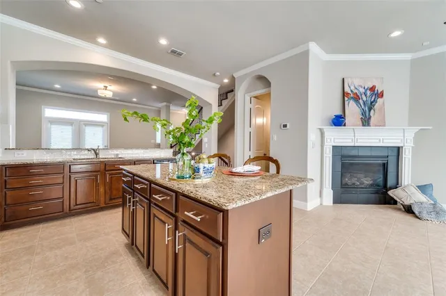 a kitchen with kitchen island granite countertop a stove and a sink