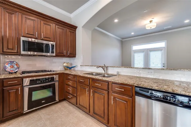 a kitchen with stainless steel appliances granite countertop a stove microwave and sink
