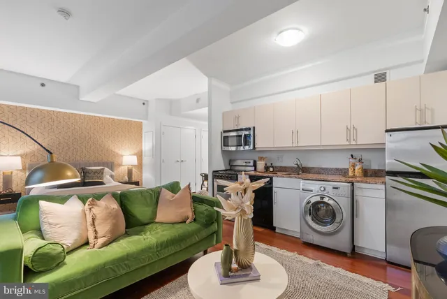 a living room with furniture a flat screen tv and a stove