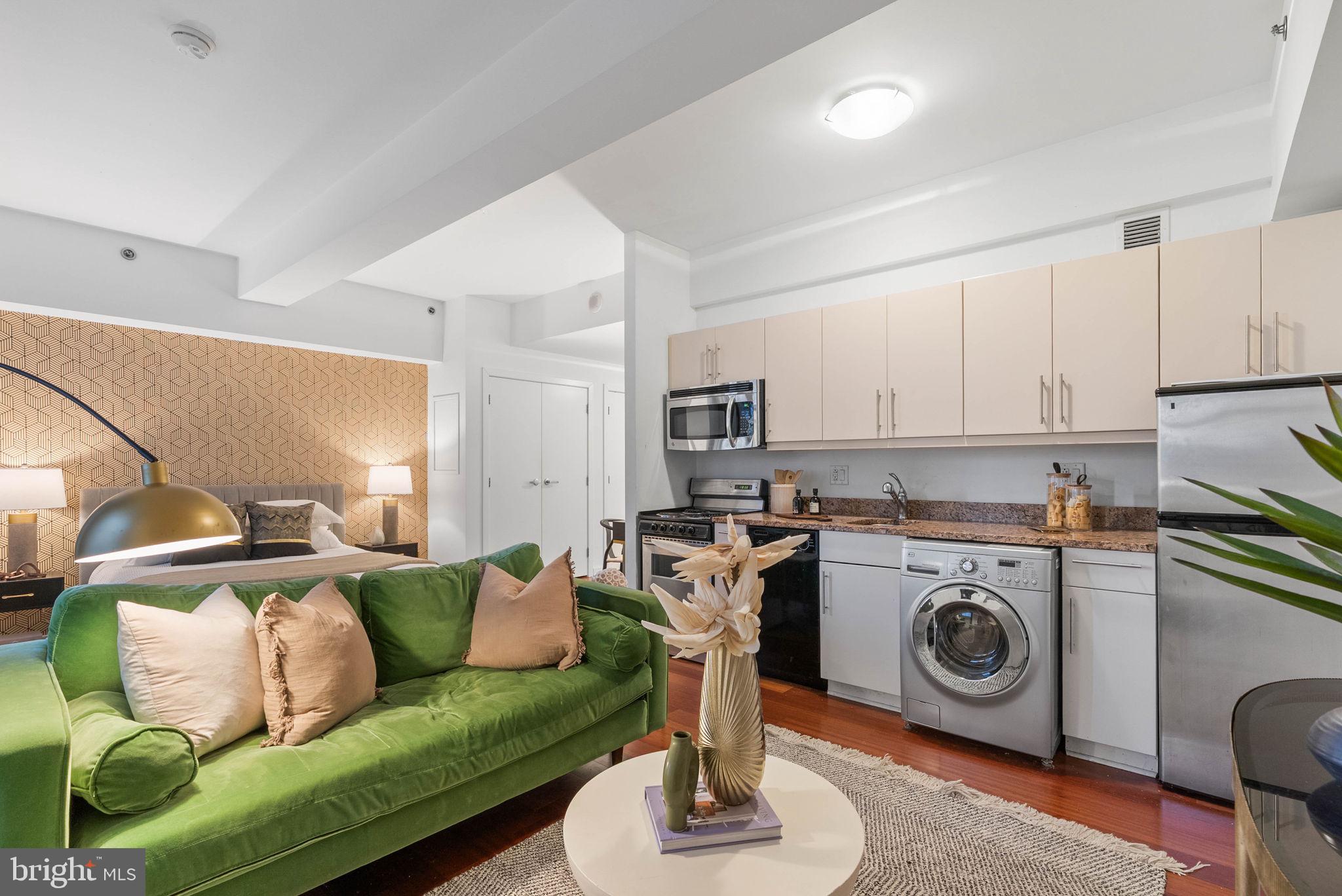219 South 18th Street, Unit 404 Philadelphia, PA 19103 - Photo 11 of 24 a living room with furniture a flat screen tv and a stove