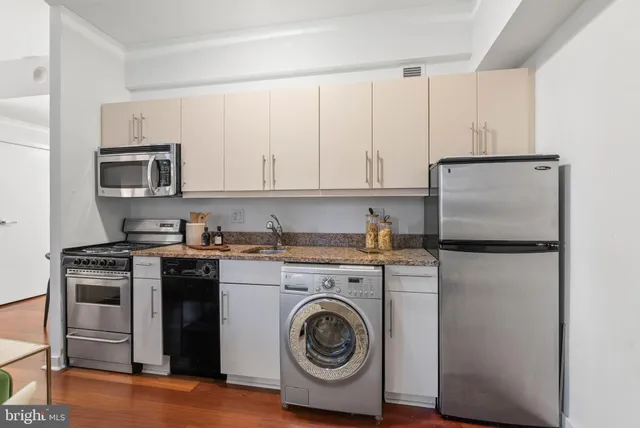 a kitchen with a refrigerator sink and cabinets