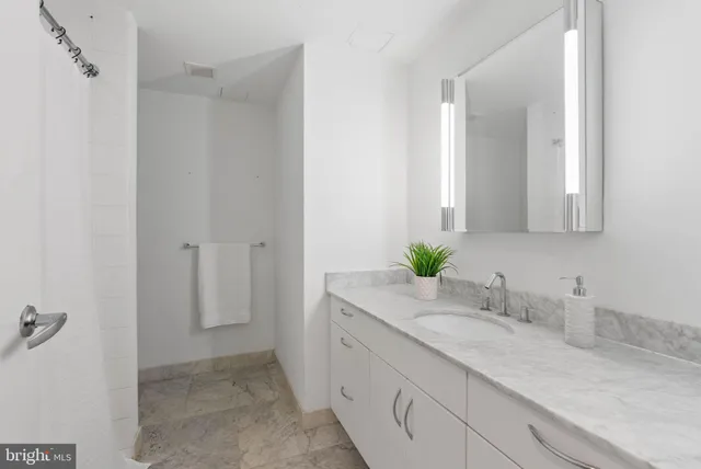 a bathroom with a granite countertop sink and a mirror