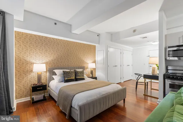 a bedroom with a bed and wooden floor