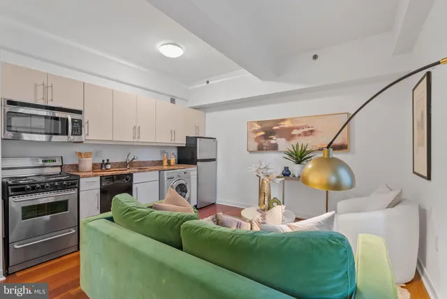 a living room with stainless steel appliances furniture and a fireplace