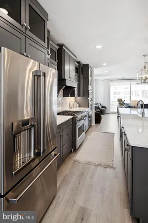 a kitchen with stainless steel appliances granite countertop a refrigerator a sink and a stove