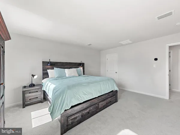 a spacious bedroom with a bed and a cabinets