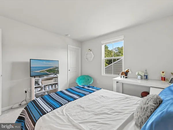 a bedroom with a bed and a flat tv screen on dresser