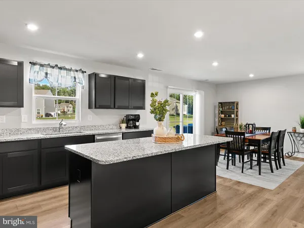 a kitchen with stainless steel appliances granite countertop sink stove window and dining table