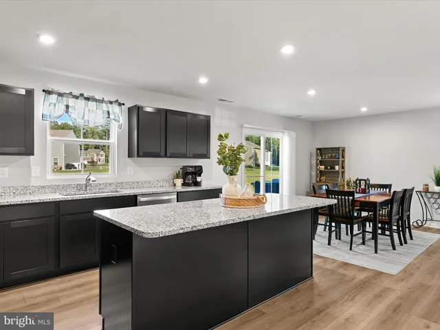 a kitchen with stainless steel appliances granite countertop sink stove window and dining table