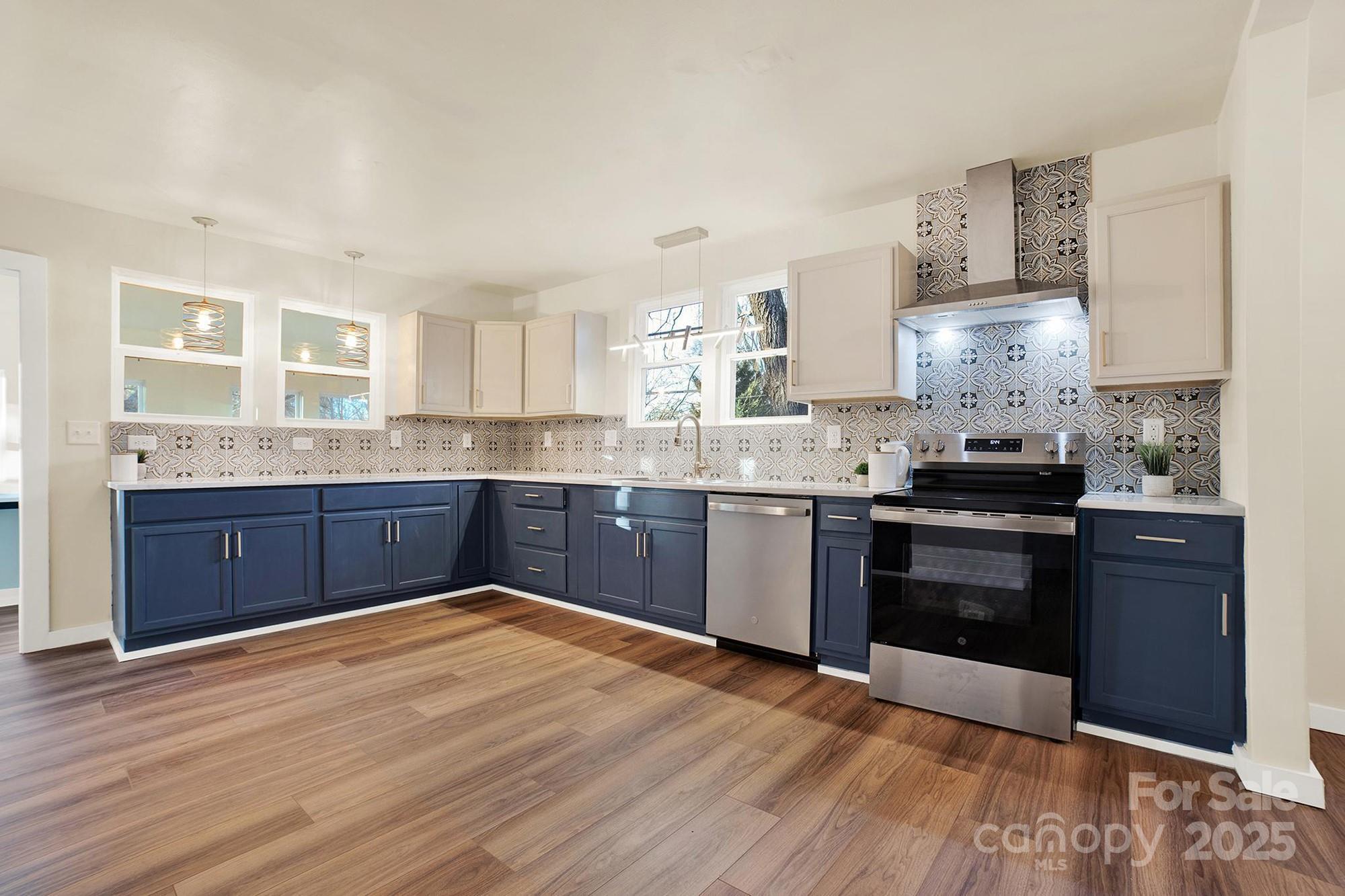 410 24th Street Southwest Hickory, NC 28602 - Photo 2 of 41 a kitchen with granite countertop wooden floors appliances and cabinets