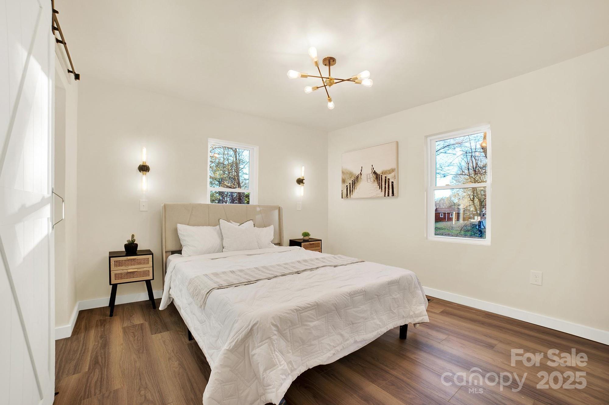 410 24th Street Southwest Hickory, NC 28602 - Photo 29 of 41 a bedroom with a large bed and a chandelier