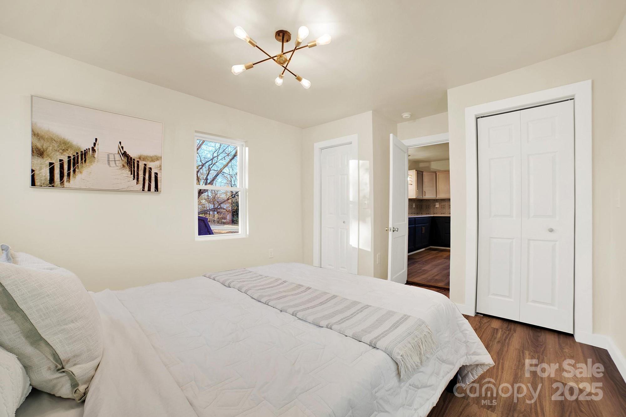 410 24th Street Southwest Hickory, NC 28602 - Photo 30 of 41 a bedroom with a large bed and a chandelier