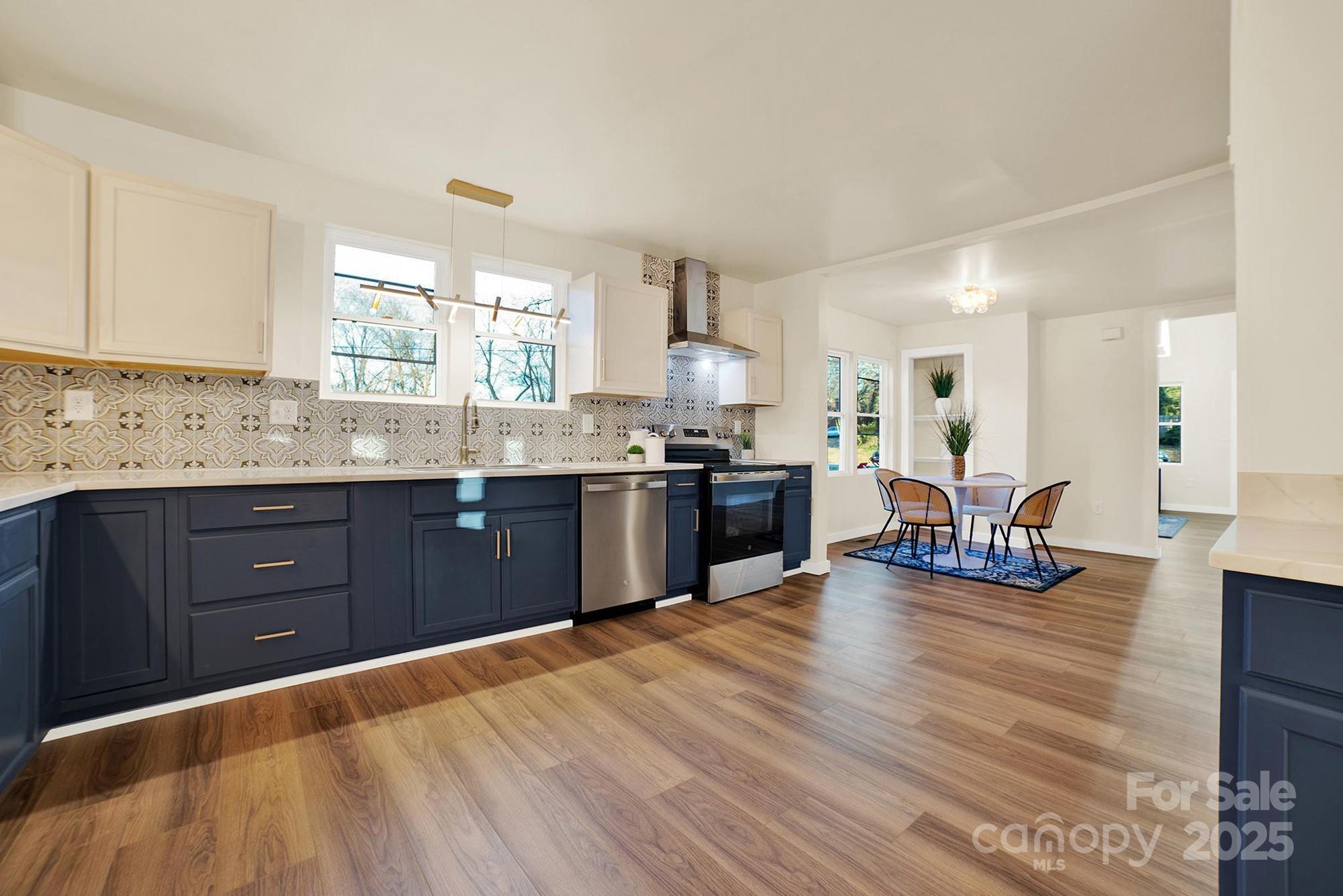 410 24th Street Southwest Hickory, NC 28602 - Photo 3 of 41 a kitchen with stainless steel appliances kitchen island granite countertop a sink dishwasher stove and cabinets with wooden floor