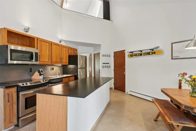 a kitchen with granite countertop a refrigerator stove and microwave