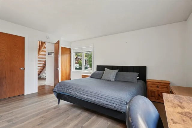 a bedroom with a bed lamp and a large window