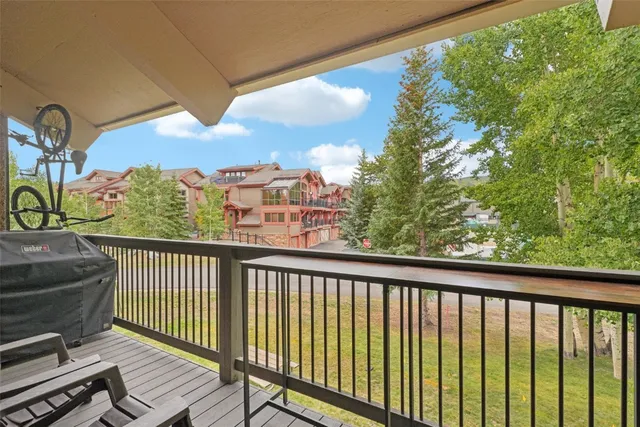 a view of a big house with a big yard and large trees