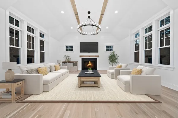 a living room with furniture a chandelier and a table