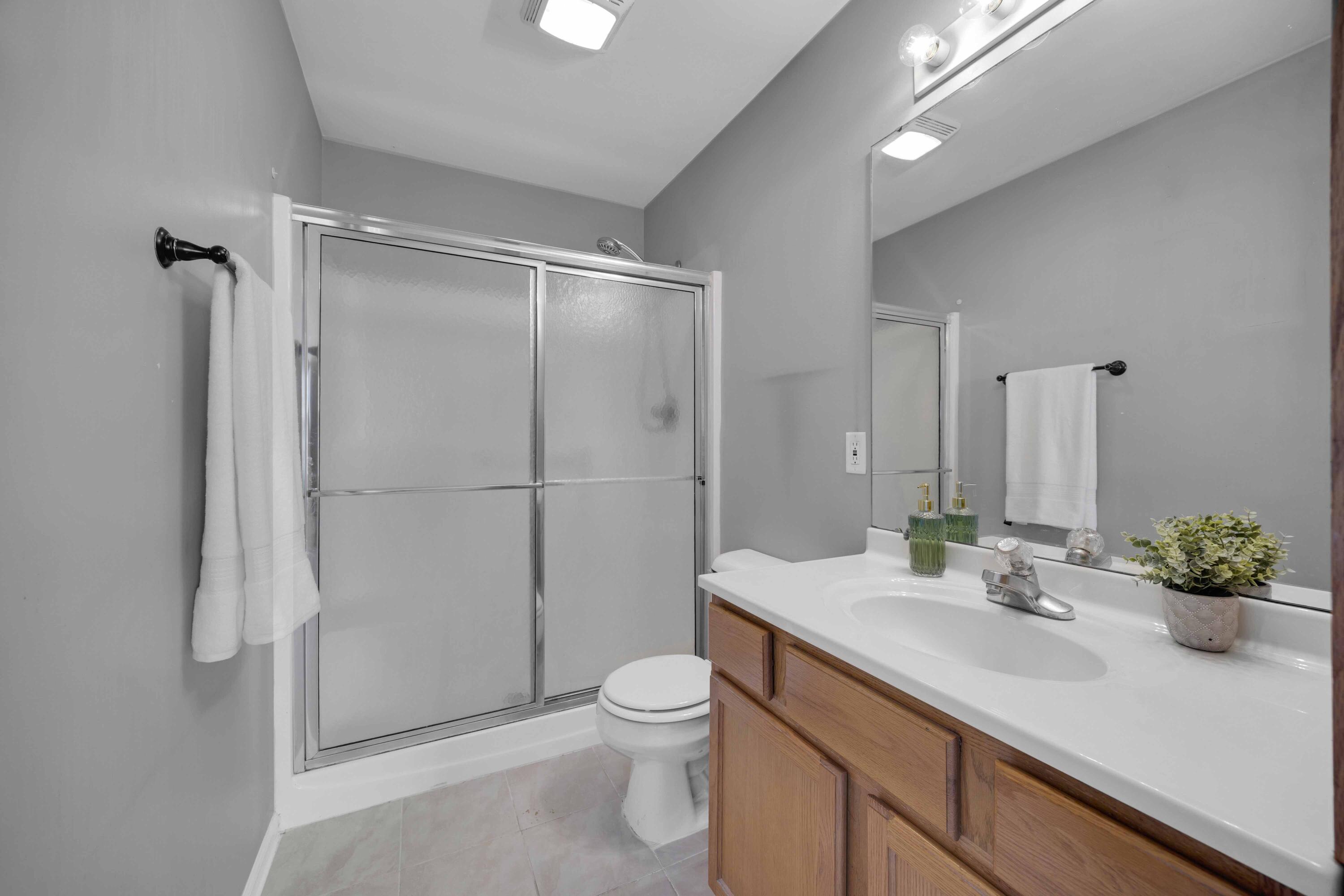 8461 Pierce Street Merrillville, IN 46410 - Photo 17 of 21 a bathroom with a shower sink vanity mirror and toilet