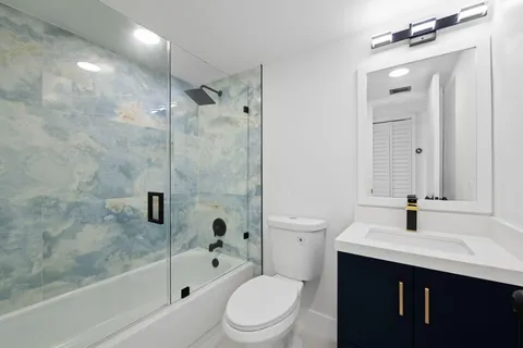 a bathroom with a sink a toilet and shower