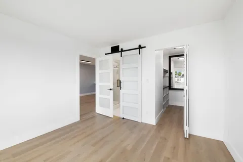 a view of a kitchen with a refrigerator and wooden floor
