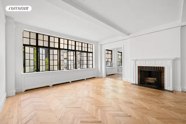 a view of an empty room with a fireplace and a window
