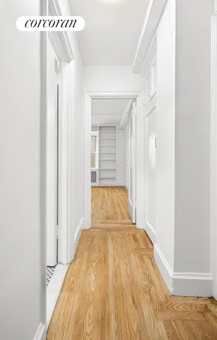 a view of a bedroom with wooden floor and a ceiling fan