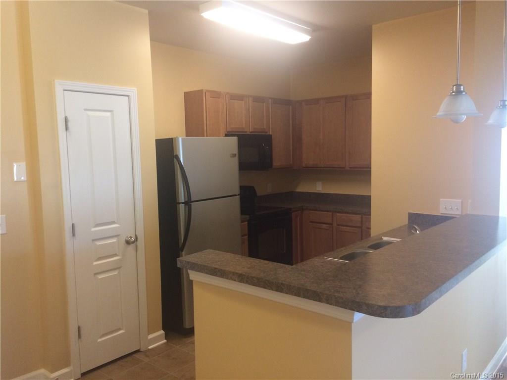 10125 Westmoreland Road, Unit 1B Cornelius, NC 28031 - Photo 3 of 15 a kitchen with stainless steel appliances granite countertop cabinets and refrigerator