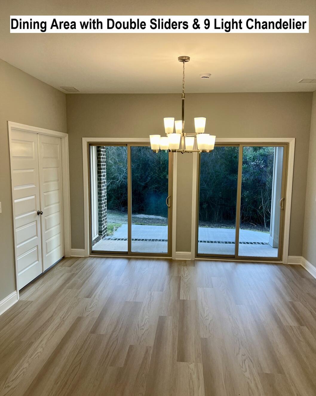 455 Scooter Cove Crestview, FL 32539 - Photo 11 of 15 a view of a room with wooden floor and chandelier