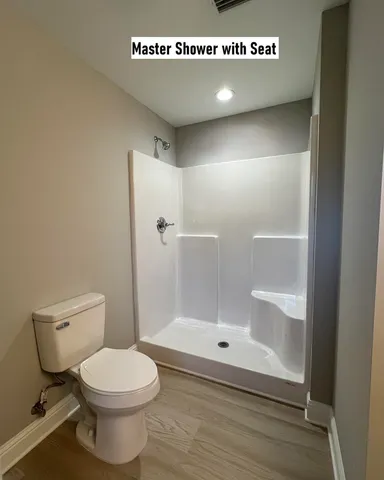 a bathroom with a toilet and a shower