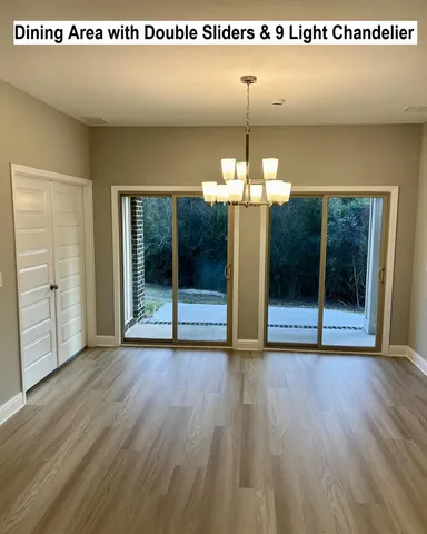 a view of a room with wooden floor and chandelier