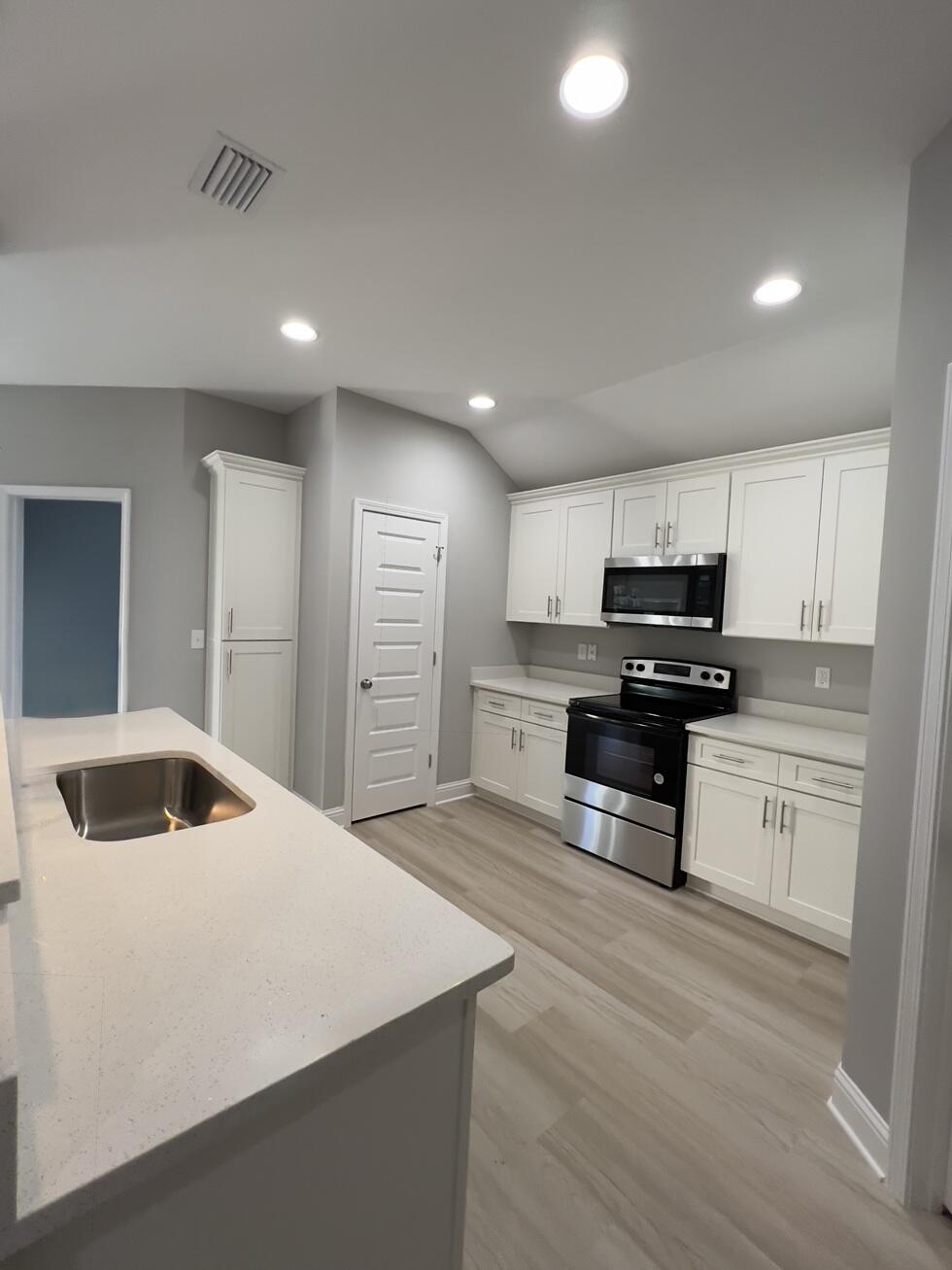 455 Scooter Cove Crestview, FL 32539 - Photo 6 of 15 a kitchen with stainless steel appliances kitchen island a refrigerator sink and cabinets