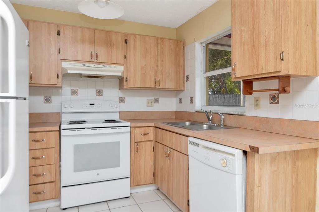 7544 Humboldt Avenue New Port Richey, FL 34655 - Photo 11 of 24 a kitchen with cabinets appliances a sink and a window