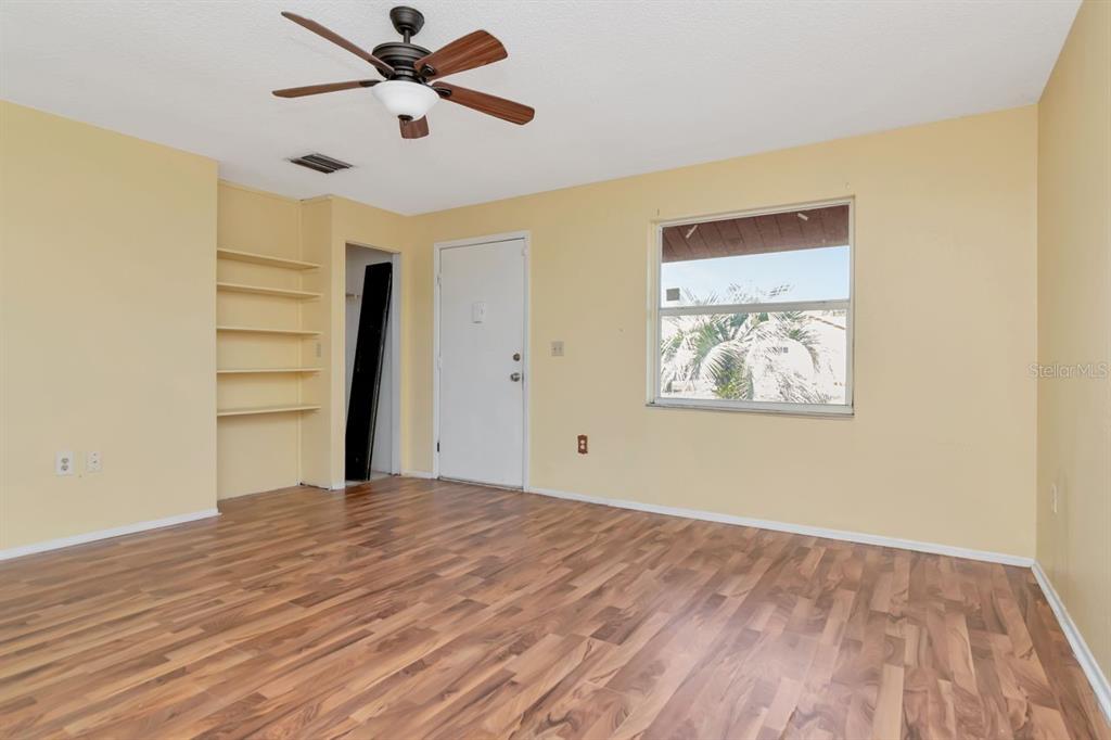 7544 Humboldt Avenue New Port Richey, FL 34655 - Photo 16 of 24 a view of a room with wooden floor and ceiling fan