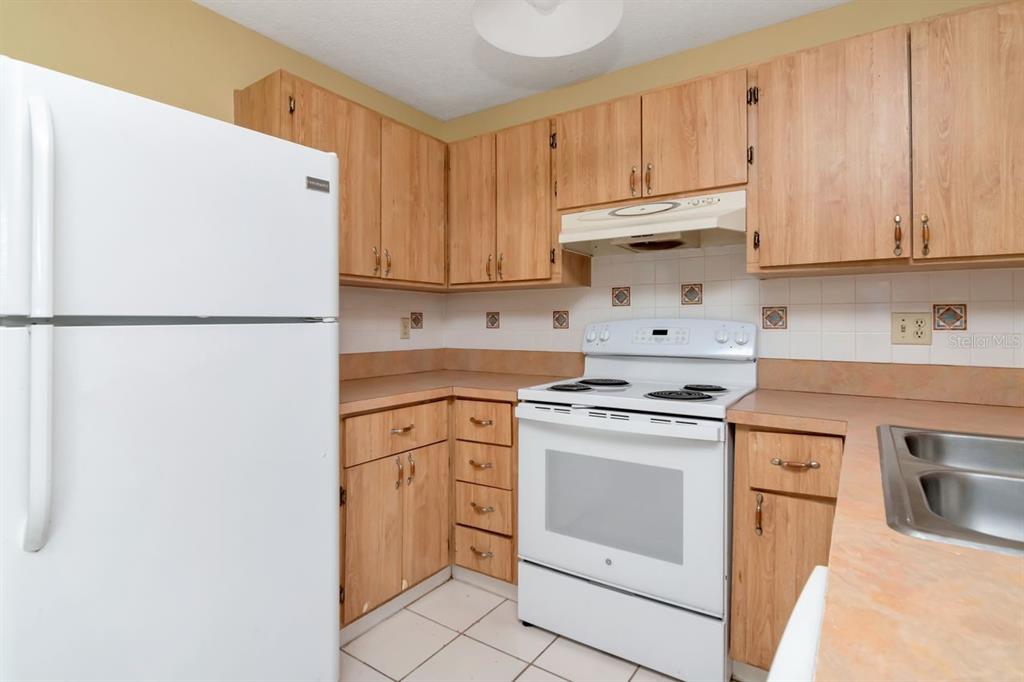 7544 Humboldt Avenue New Port Richey, FL 34655 - Photo 9 of 24 a white refrigerator freezer sitting inside of a kitchen