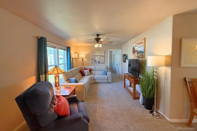 a living room with furniture a large window and a flat screen tv
