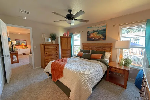 a bedroom with a bed and dresser with wooden floor