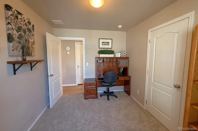 a view of a workspace with furniture and a window