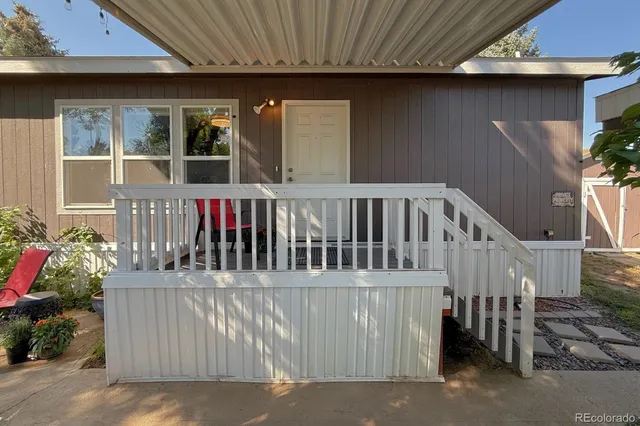 a view of a house with wooden deck and furniture
