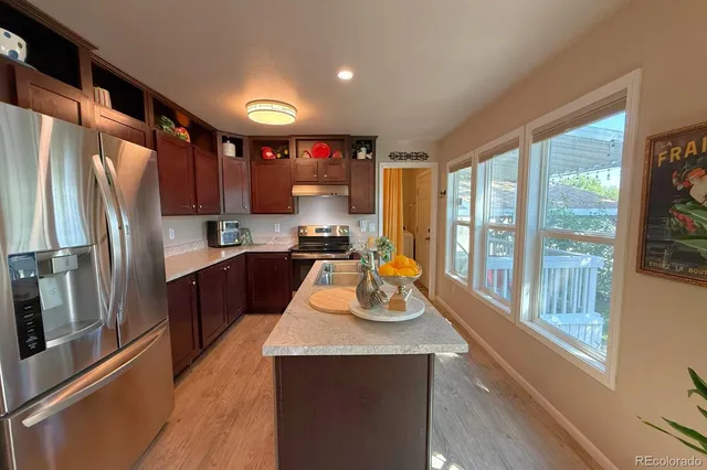 a kitchen with a refrigerator a sink and a stove top oven