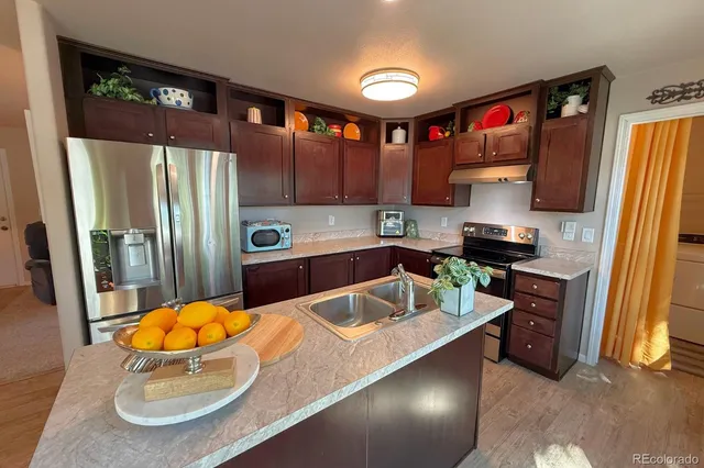 a kitchen with a sink a refrigerator and a stove