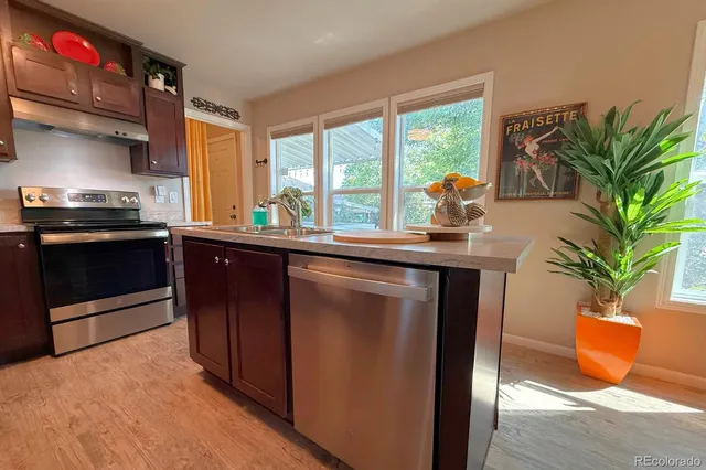 a kitchen with stainless steel appliances granite countertop a stove a sink and a microwave