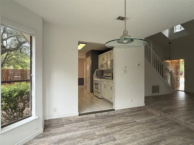 a view of a kitchen with wooden floor and a window