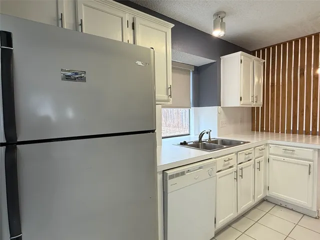 a white refrigerator freezer sitting inside of a kitchen