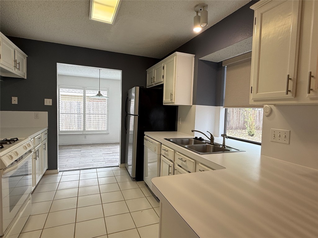 2503 Autrey Drive Leander, TX 78641 - Photo 14 of 39 a kitchen with granite countertop a stove a sink and a refrigerator
