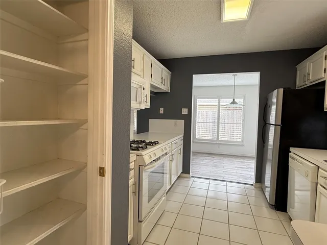 a kitchen with a refrigerator and a stove top oven