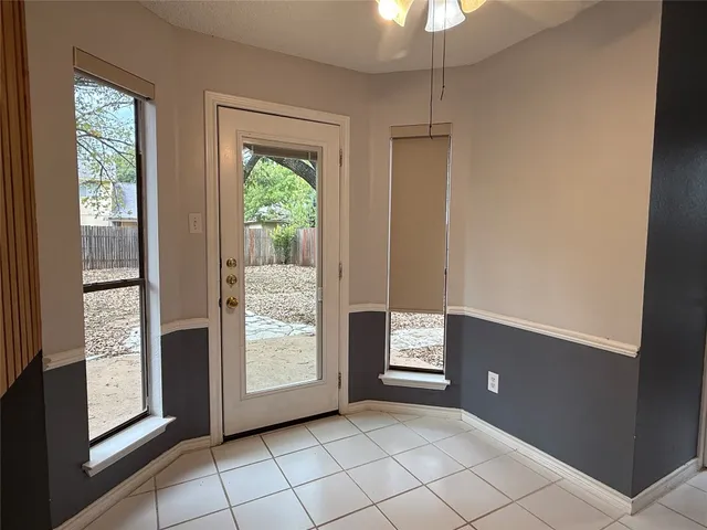 a view of an empty room with window and cabinet area