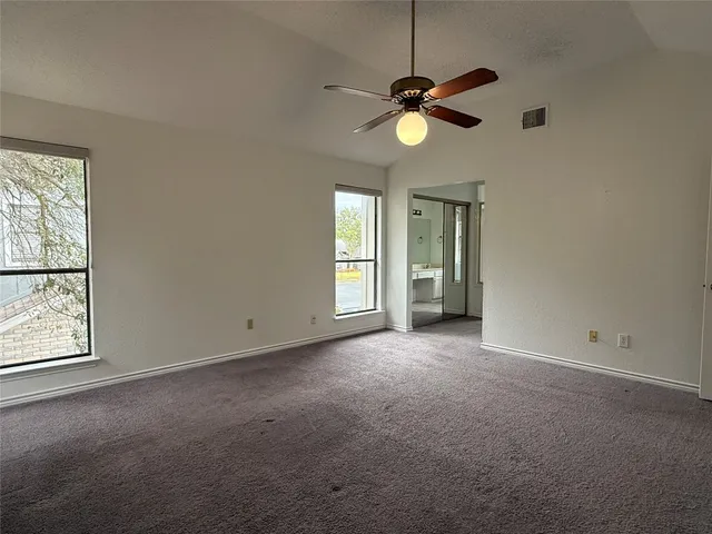an empty room with fan and windows