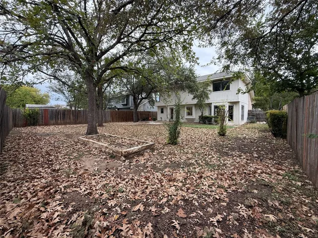 a view of a white house with a yard and large tree