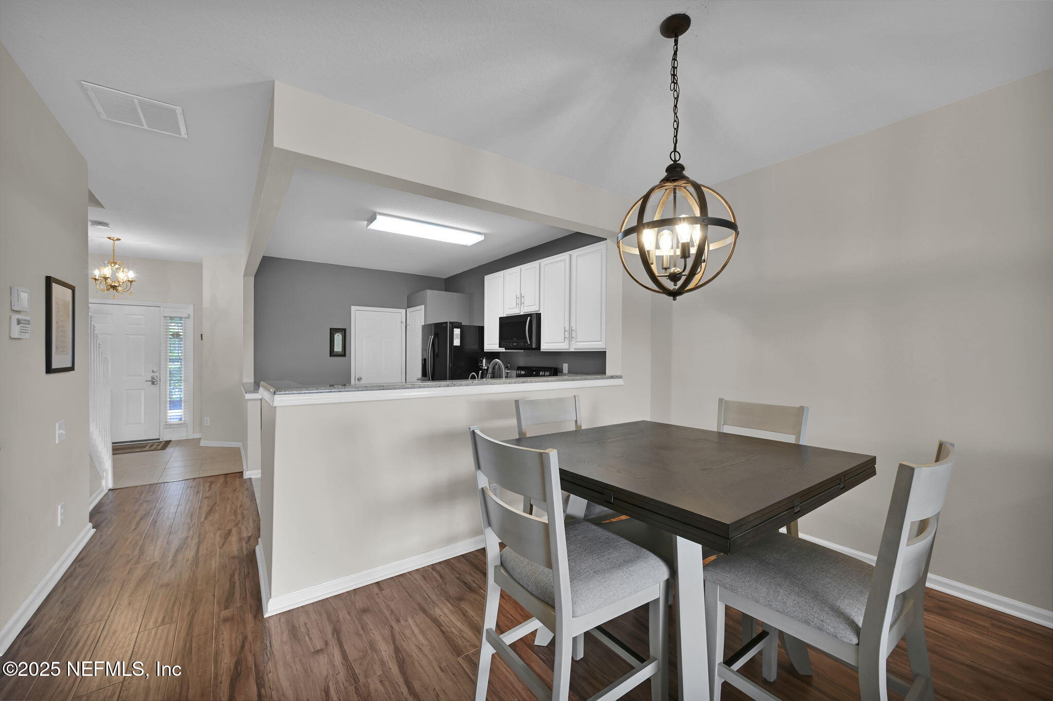 7990 Baymeadows Road East, Unit 2302 Jacksonville, FL 32256 - Photo 14 of 66 a view of a dining room with furniture wooden floor and a chandelier