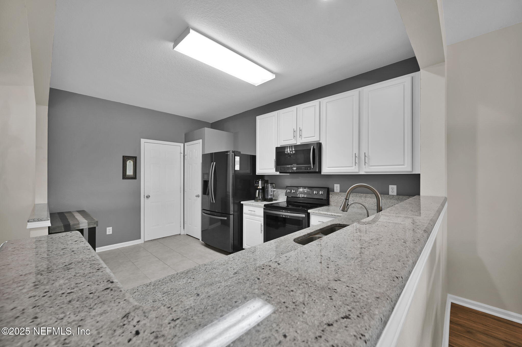 7990 Baymeadows Road East, Unit 2302 Jacksonville, FL 32256 - Photo 15 of 66 a kitchen with stainless steel appliances granite countertop a sink refrigerator and microwave